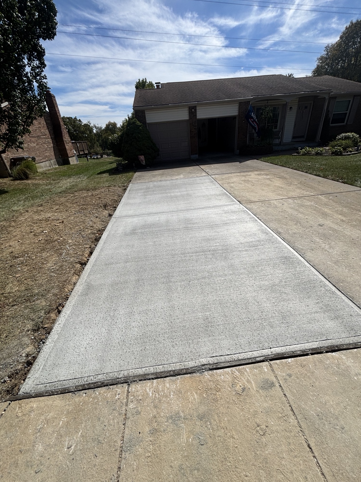 New broom-finished concrete driveway after replacement